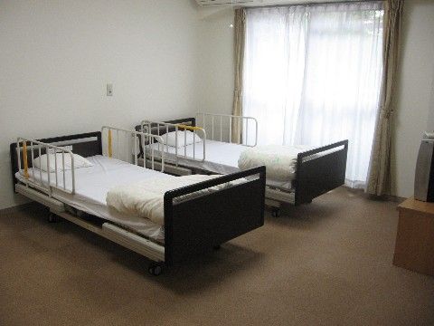 ベッドが２台とテレビが一台置いてある、窓から日が差し込む明るい２人用の居室