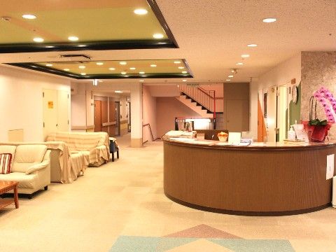 円形のカウンターがある目の前に布張りのソファが置かれた温かみのある受付場所