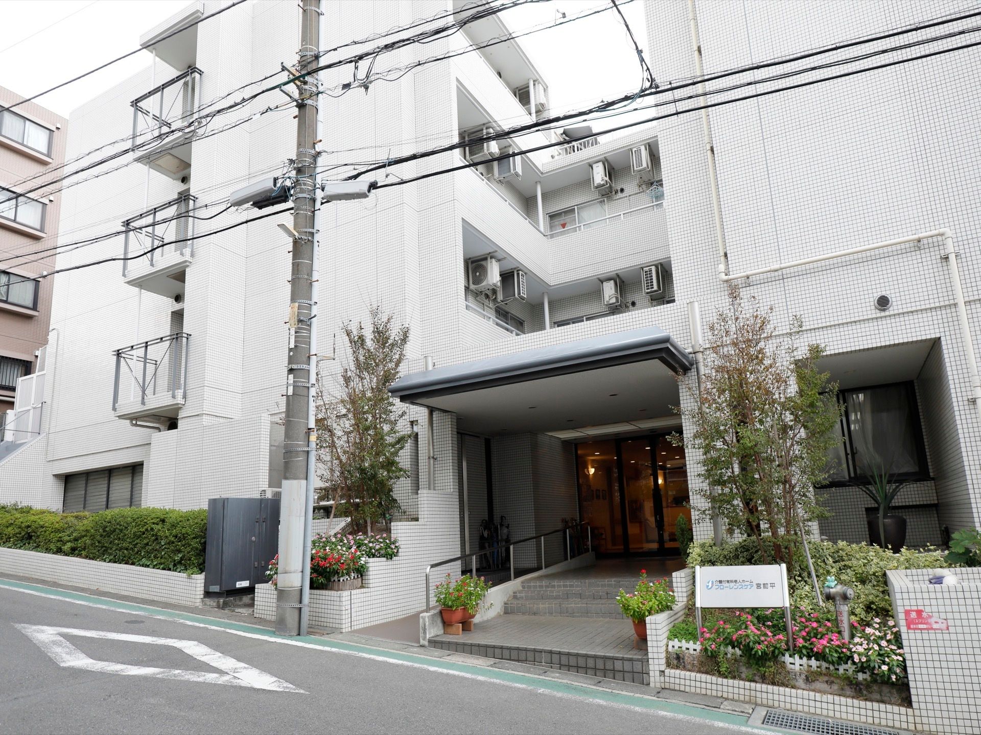 白色を基調としたマンションのような構造の４階建て施設である。玄関前には手すりのついたスロープがある。