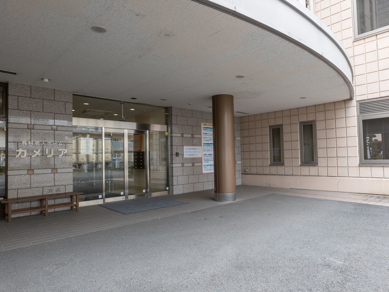 笑顔で薬を飲む高齢女性とお水を差し出す女性スタッフ