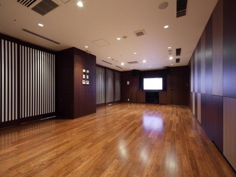 フローリングの床に防音壁のシンプルで広いスペース。正面には大きなモニターがついている。空調設備もついている。