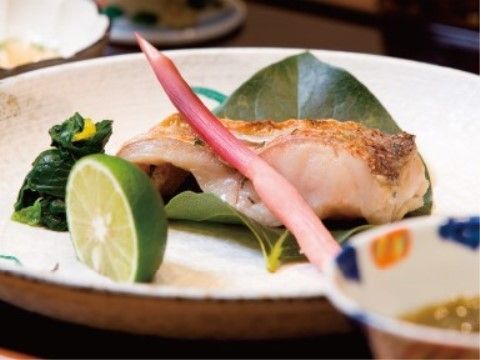葉しょうがや柑橘類を添えた魚の焼き物