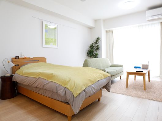 白い白い壁にフローリングの寝室