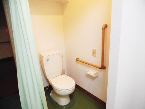居室内のトイレには、L字型手すりや呼び出しブザーが設置されている。入居者様は安心して用をたすことができる。