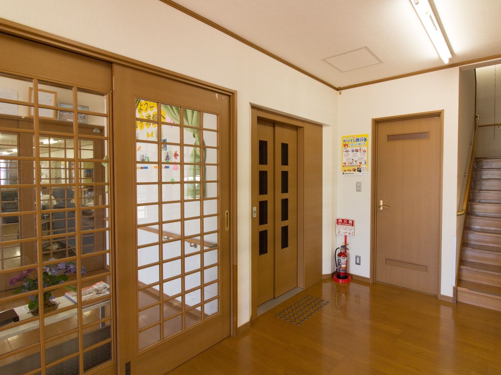 玄関ホールのすぐ側に、階段とエレベーターが備えつけられている。壁際には消火器があり、緊急時への対策が講じられている。