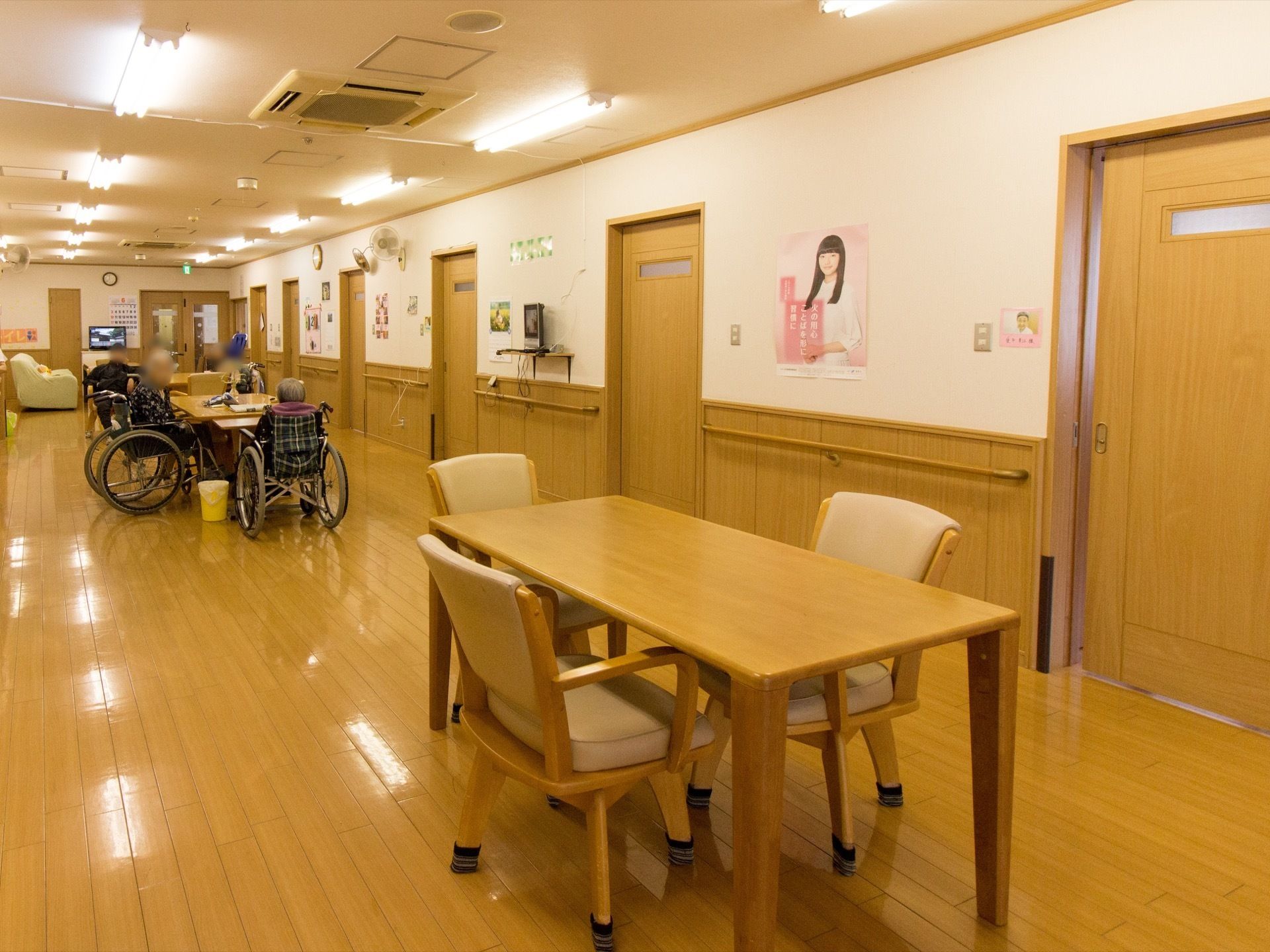 ライトブラウンの椅子とテーブルが、ゆったりとした間隔で配置されている。フローリングの床は、段差のないバリアフリー仕様である。