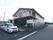 建物前の駐車場に車が2台とまっている外観