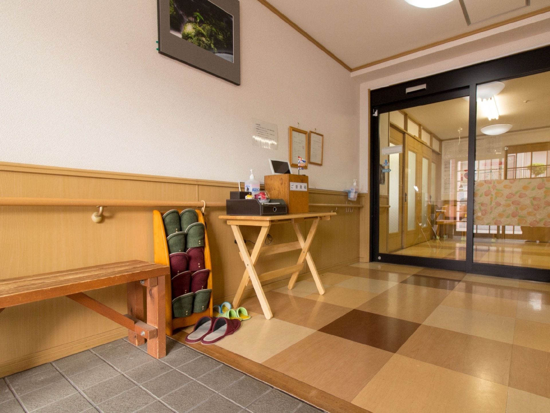 段差のない玄関には、靴を履くときに利用できる椅子や手すりなどがある。また、来訪者様用のスリッパも用意されている。