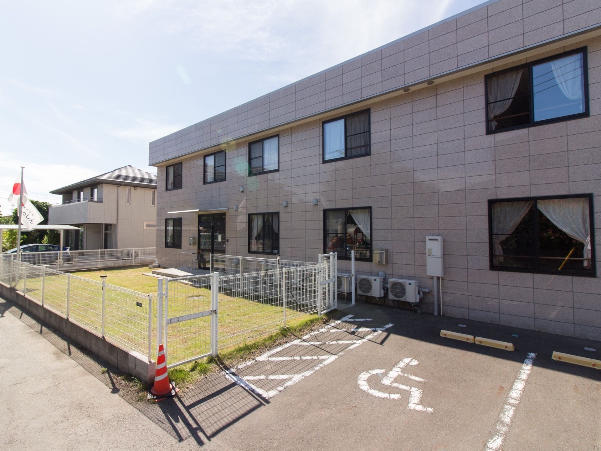 ２階建ての大きな四角い建物である。玄関前には芝生が植えられており、柵で囲われている。すぐ近くに駐車場がある。