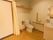 居室にはカーテンで仕切られたトイレと洗面台が設置されている。トイレの両側には手すりが取り付けられ、安全面への配慮がなされている。