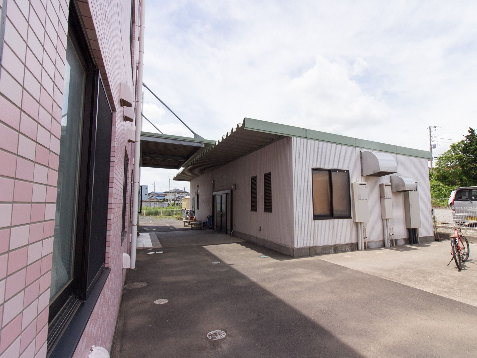 広い敷地に4階建ての施設である。周囲に高い建物がなく青空が広がっている。のどかな環境で閑静な住宅地である。