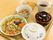 ご飯に汁物、お茶、いろどりの良い煮物と、ごぼうの小鉢、デザートのワッフルがついた食事をトレーにのせてある。