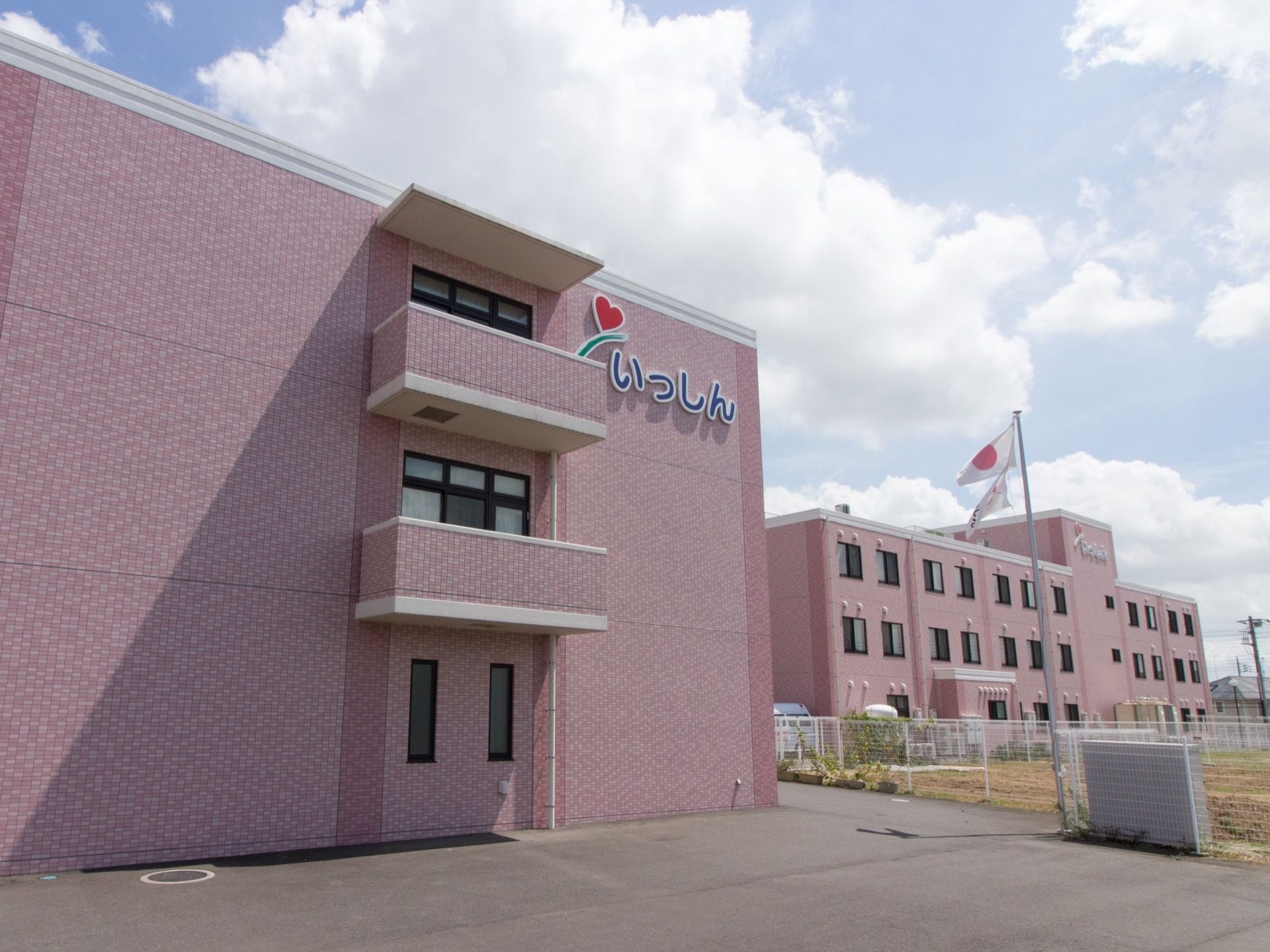 優しい桃色の外観である。３棟の施設を併設し、入居者様の交流を積極的に図っている。触れ合うことで張りのある生活を送ることができる。
