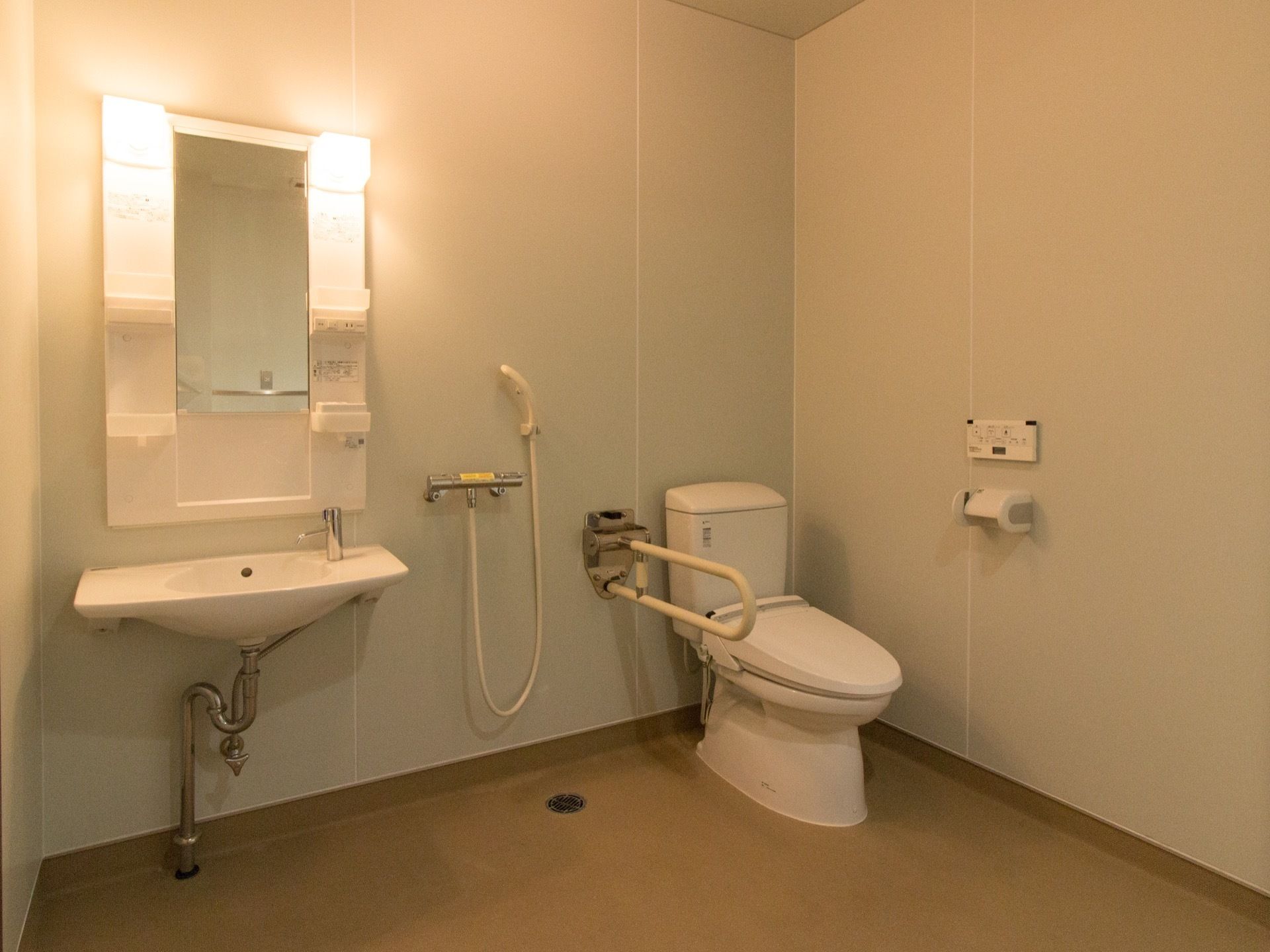 トイレには温水洗浄便座を取り付けている。壁に取り付けられたパネルで操作するタイプを採用している。便座横には折り畳み式の手すりがある。