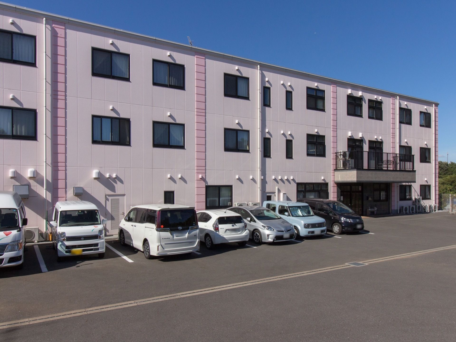 施設前に駐車場があり、入り口前まで車を寄せることができる。玄関には屋根がせり出し、屋根の上はベランダになっている。