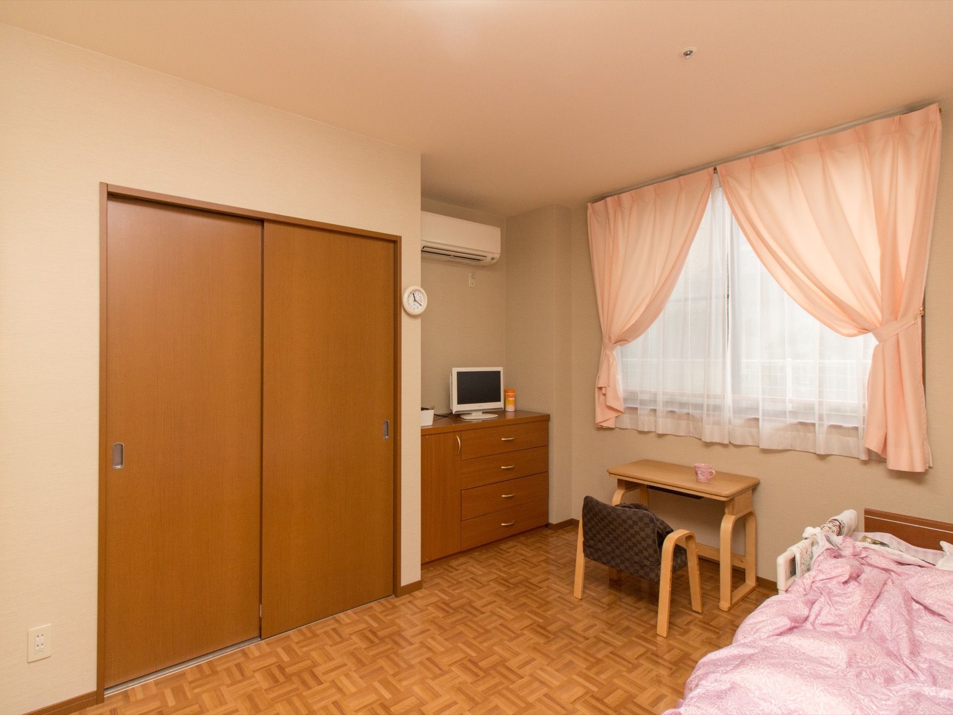 明るく落ち着いた雰囲気の居室には、木の温もりが感じられる家具が配置されている。窓からは日も差して明るいので、居心地の良い雰囲気になっている。