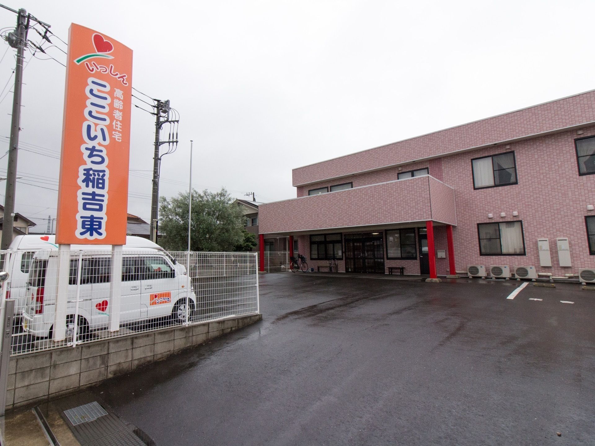 ２階建てで暖色系の明るい外観が印象的な建物。エントランス側に駐車スーペースが設置されている機能的な造りになっている。