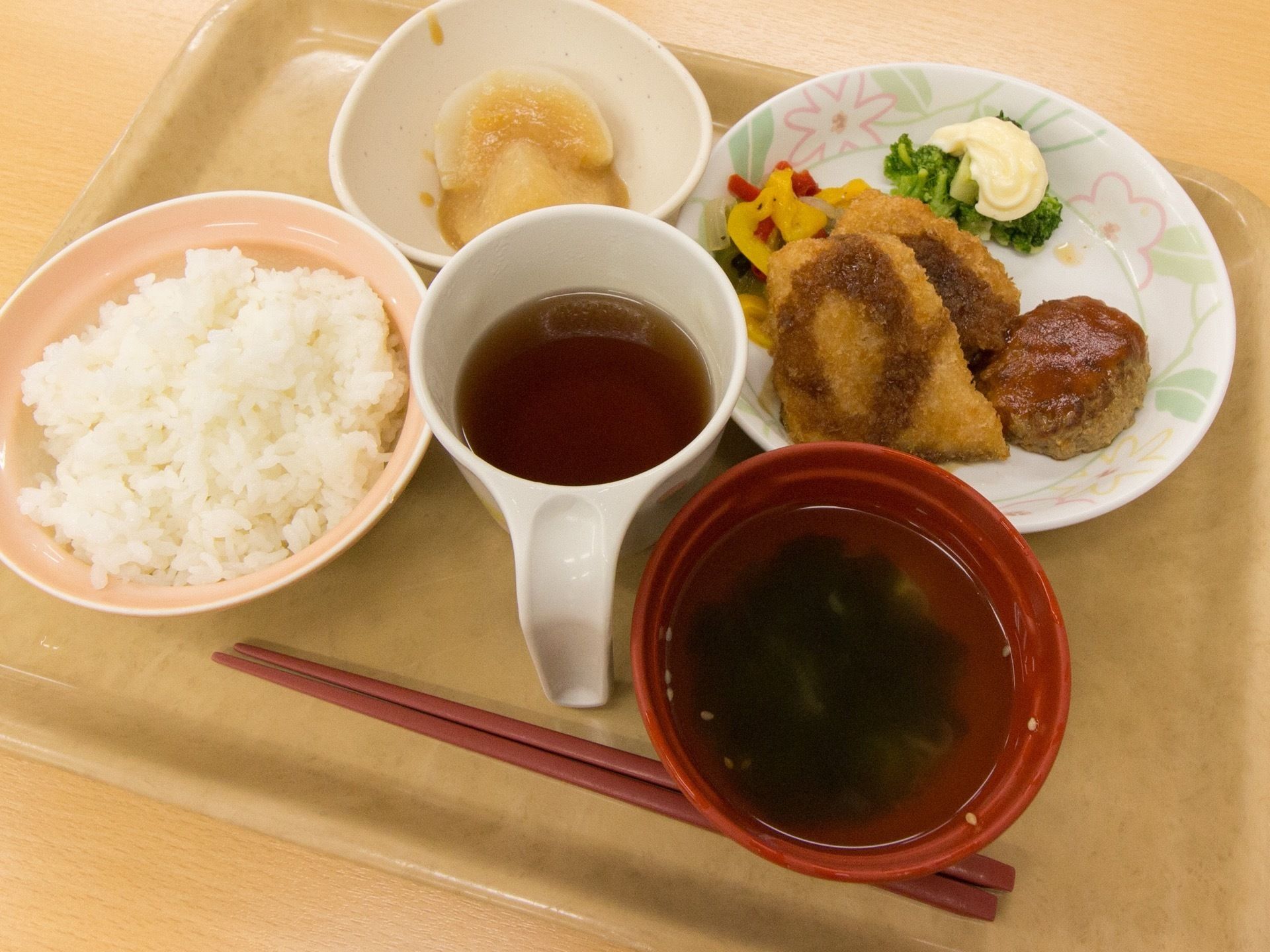 明るい色の食器に、食事がバランスよく配膳されている。主菜と副菜の品目が多く、飽きずに食べられるメニューである。
