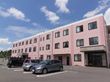 ピンク色の３階建の建物である。駐車場から玄関に到るまで段差はなく、緩やかなスロープになっている。出入り口が２箇所についている。