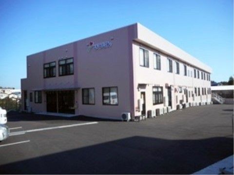 駐車場の向こうにある、左側に玄関のある2階建ての建物