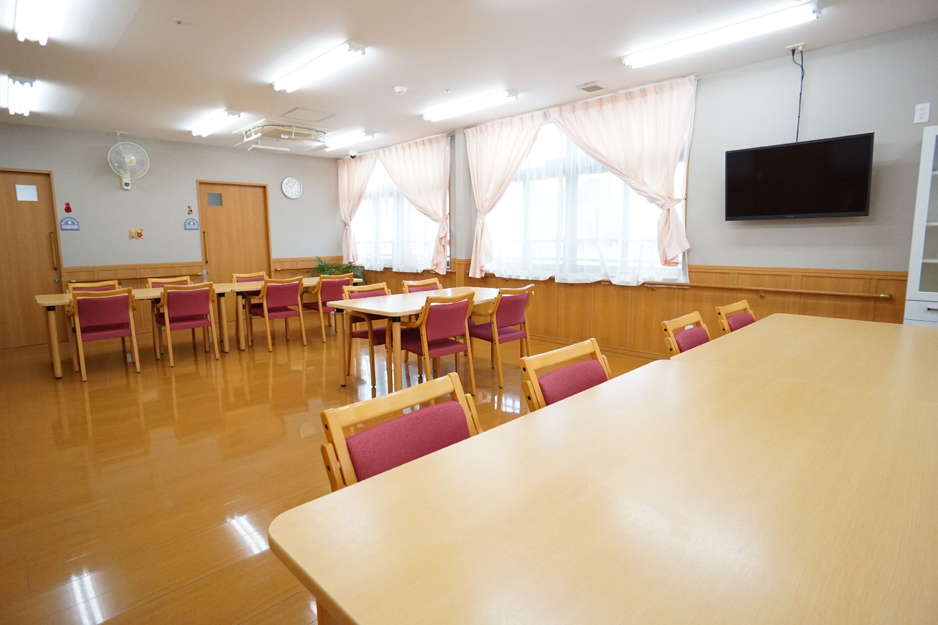 窓が多く設置されて日差しが降り注ぎ、開放感のある共有スペース