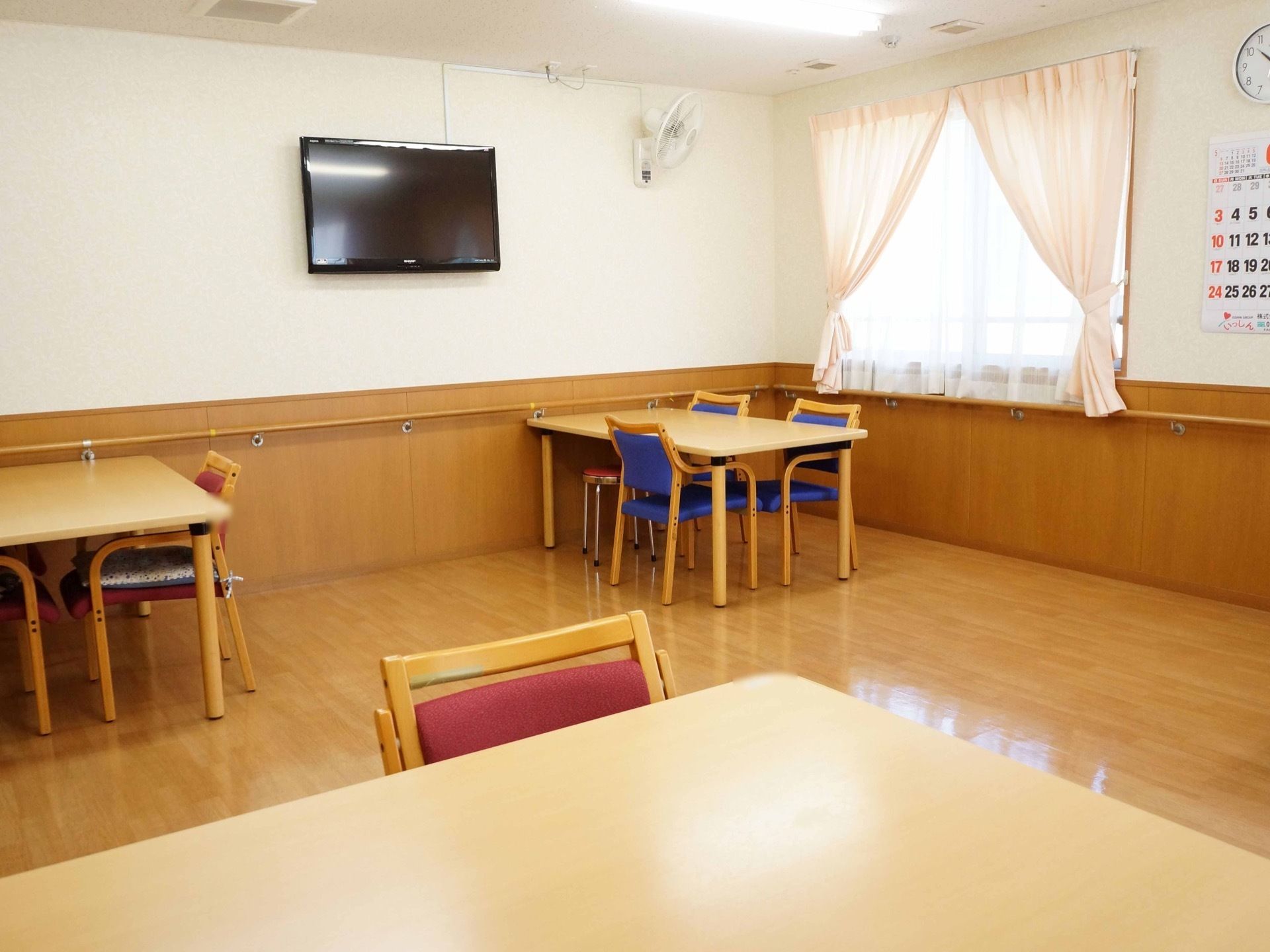 壁にはテレビや扇風機が設置されており、手すりも備え付けられている。窓が大きく明るい空間になっている。