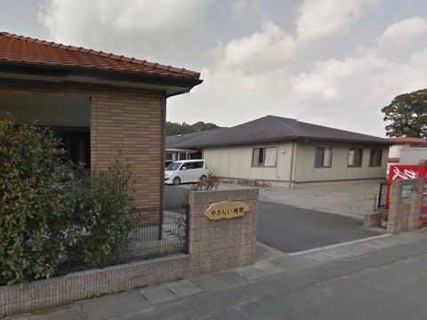 あたたかい色合いのレンガ造りの建物である。施設の入口付近には緑が植えられている。駐車場も完備している。