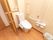 居室のトイレ内の壁紙は、イエロー系で明るい雰囲気である。トイレのタンクの後ろには棚があり、小物を入れた籠などを置くことができる。