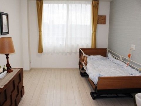 居室には大きな窓があり、明るい日差しが入る。窓にはレースのカーテンがかかっている。洗面台が設置されている。
