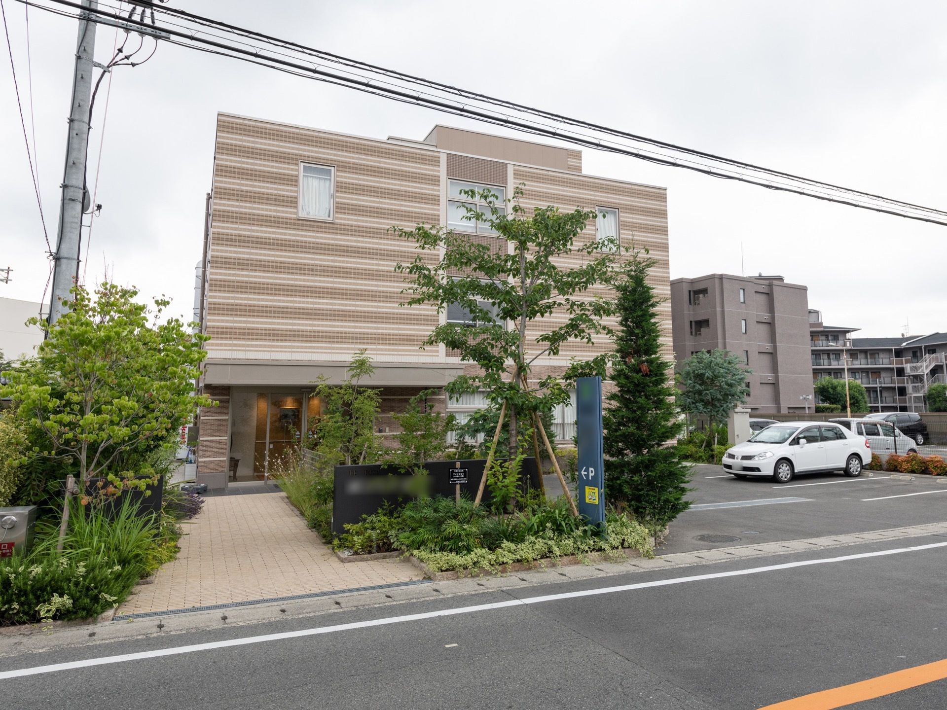 施設は、道路沿いに建てられており、マンションのような作りになっている。玄関アプローチには、両脇に緑が植えられている。