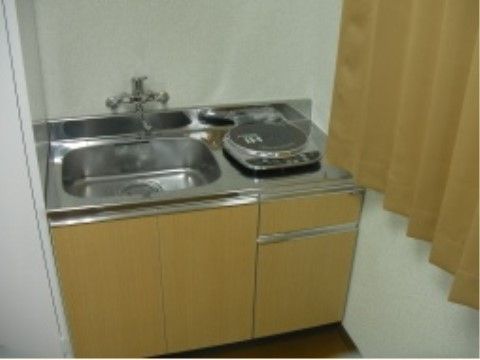 居室に備え付けられているシンプルなキッチンである。シンクの横には、１口のIHコンロが設置されている。