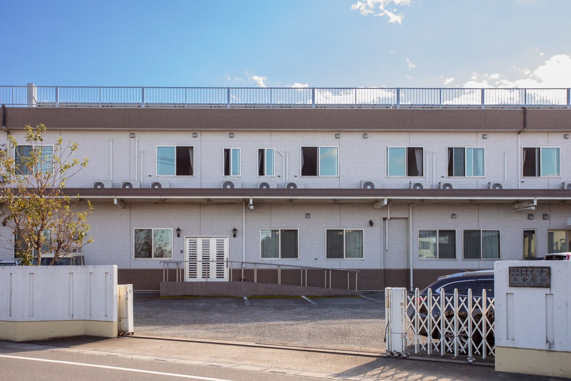 ２階建ての施設には屋上があり、窓が多い。転落防止と雨除けを兼ねてひさしが長く突き出ている造りになっている。