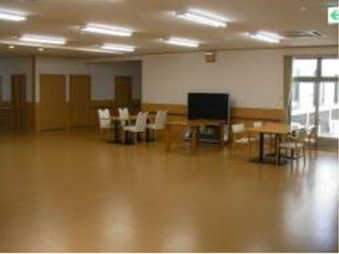 仕切りのないフローリングの広々としたスペースの一角に、椅子と机、テレビが置かれている。窓があり、照明も十分で明るい。