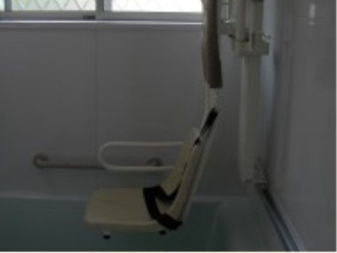 座ったままご入浴いただける、リフトと機械浴層が設置されている。浴室は白を基調とした内装で、窓があり、手すりが付いている。