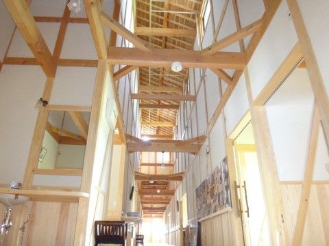 屋根の垂木や梁がむき出しになっている、高い吹き抜けの廊下