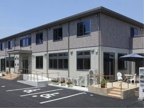 ベージュのツートンカラーの2階建ての建物の前にある駐車場