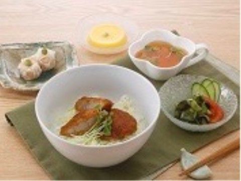 どんぶりに肉のようなものが乗ったごはん、シュウマイやサラダ、スープが添えられた食事例