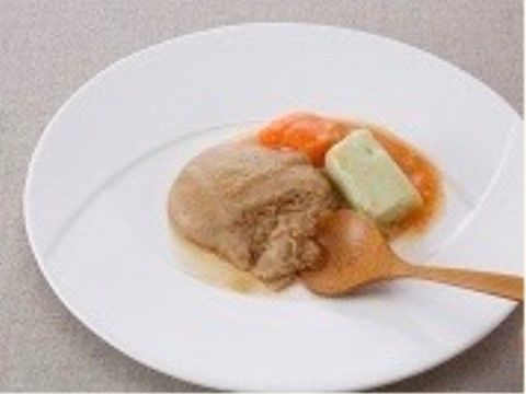 白い皿にチョコレート色、黄緑、赤色のものが盛られ、木のスプーンが添えられた料理