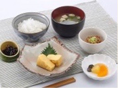 卵焼きに小鉢が2つ、漬物や味噌汁も添えられた朝食例