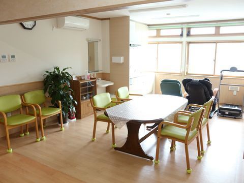 フローリングにテーブルクロスのかかったテーブルが置かれ、椅子がセットされている共用スペース