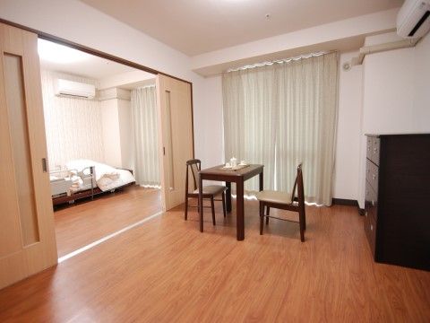 居室の右側には焦げ茶色の収納ダンスが設置されており、入居者様の衣類、タオル、日用品などを整理整頓することが可能である。