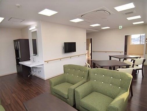 外壁が白と濃いブラウン色をした、重厚感のある３階建ての建物