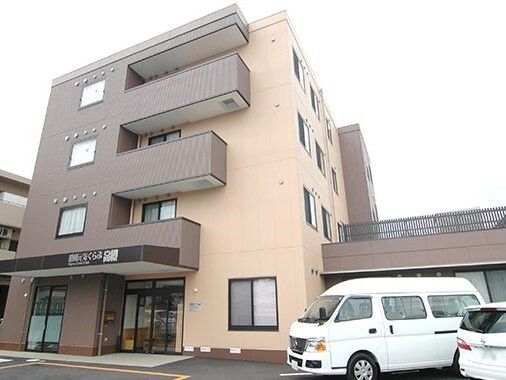 茶色とライトイエローの壁面で、プランターが周りに置かれた施設