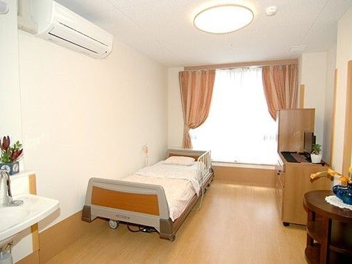 車椅子に乗った高齢女性と介助をする女性ヘルパー