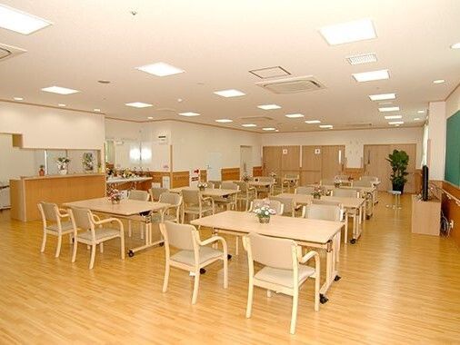 手を叩いてレクリエーションを楽しむ高齢女性と女性スタッフ