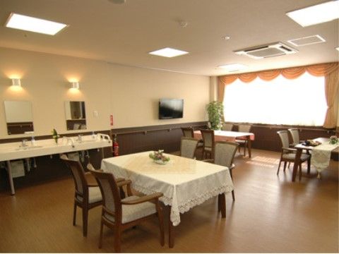 広々としたフローリングにある4人掛け用のテーブルと観葉植物