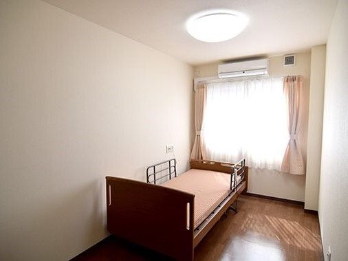 輪になってレクリエーションを楽しむ高齢女性と女性スタッフ