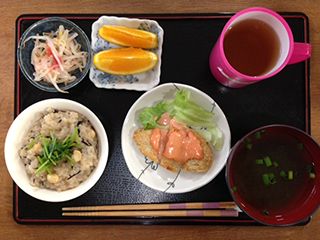 炊き込みご飯とスープ、ソースのかかった揚げ物、サラダやフルーツが付いた食事例