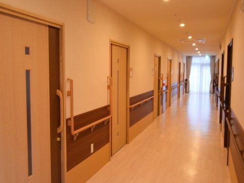 廊下は淡いクリーム色の明るい内装である。手すりが設置されており、足腰に不安がある入居者様でも安心して歩行できる。