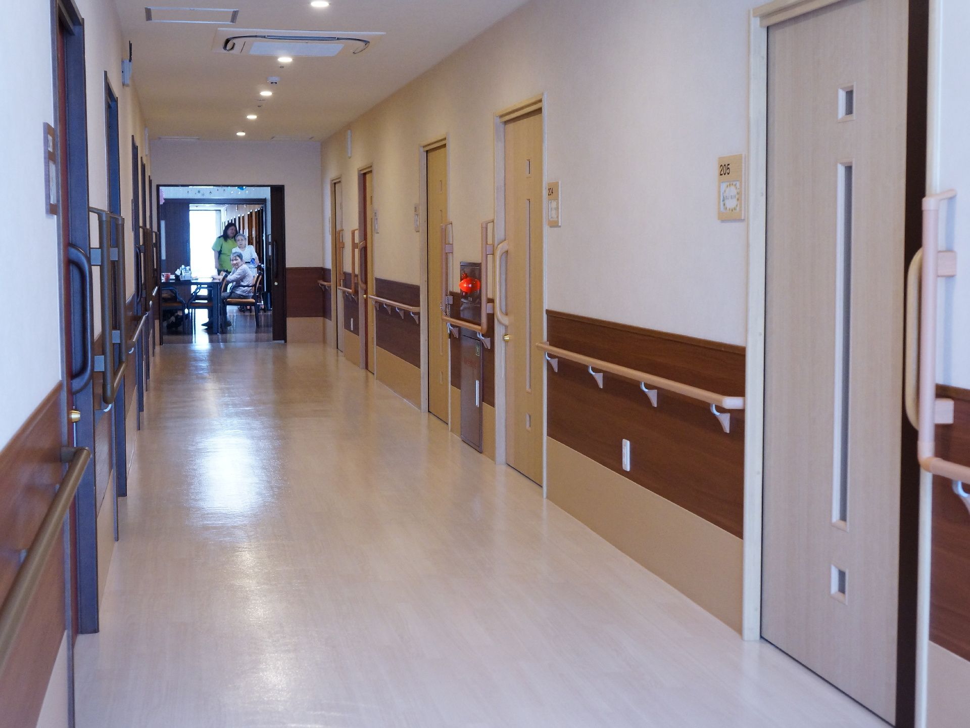 廊下の両側に居室が並ぶ設計となっている。廊下を真っ直ぐにすることで見通しが効き、移動もスムーズに行なえる。廊下の中間に居間兼食堂がある。